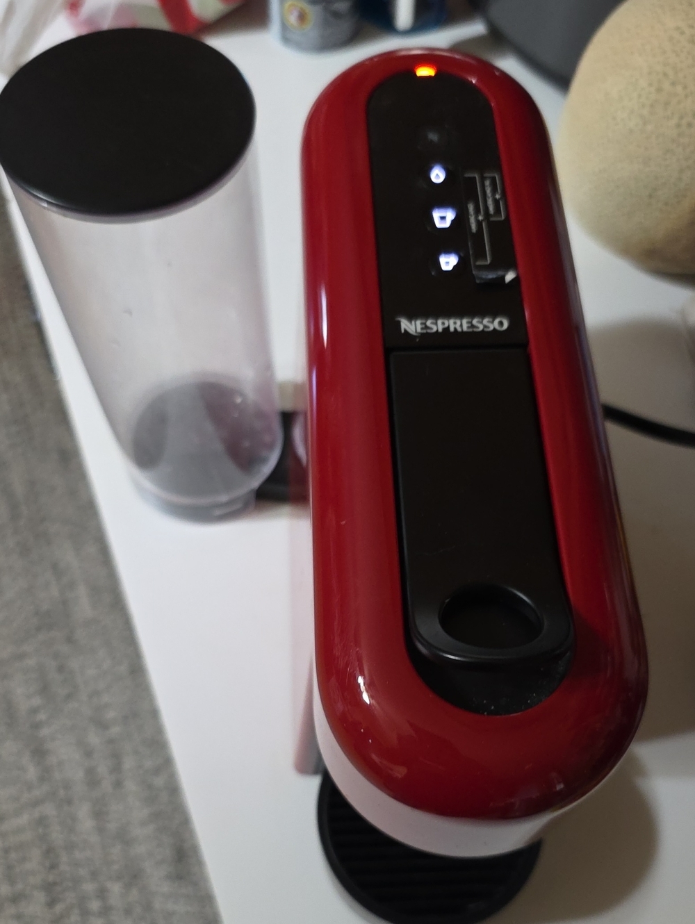 Nespresso glossy red single-serve coffee machine with black accents